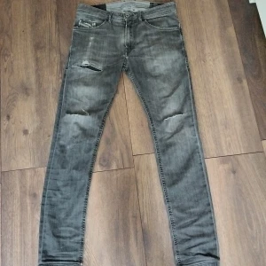 Gråa diesel jeans med slitningar  - Gråa diesel jeans med slitningar i modellen thommer(Slim). Storlek W30/L32. Hål på båda knäna samt lagade i rumpan. Skriv vid minsta frågor eller funderingar 💯