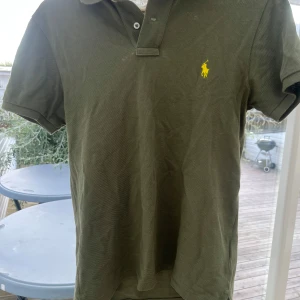Olivgrön Polo Ralph Lauren piké  - Säljer nu min feta Ralph Lauren piké då den är för liten. Den är i bra skick, inte använd sådär jättemycket. Den ska tvättas är en liten smuts fläck vid bröstet! Vid frågor hör av er//Elvin