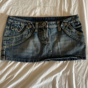 Jeans minikjol med detaljerade fickor - Supercool jeans minikjol i blå denim med slitna detaljer. Kjolen har flera fickor fram och bak. Buda om du vill💕💕
