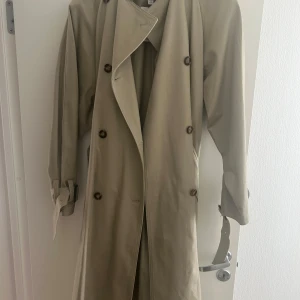 Beige trenchcoat med bälte - En helt ny kappa från hm i storlek xs, den är stor i storleken då jag själv brukar ha M egentligen. Prislapp finns på. Ordinarie pris 700 kr! (Köpt för 2 veckor sedan) 