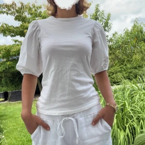 Vit blus med puffärmar  - Superfin vit blus från Gina Tricot med puffiga korta ärmar! Toppen är i mjuk bomull och har en clean, stilren look som passar perfekt till jeans eller kjol. Helt oanvänd! 😊Strolek XS men passar till en S-M. Nypris: 399 kr. Nu: 199 kr. Hör vad dig för fler bilder/frågor! 😁☀️🌸