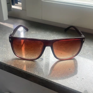 Rayband boyfriend - Säljer ett par snygga solglasögon med stora, fyrkantiga bågar i transparent brun plast. Glasen är tonade i brunt och ger en cool vintagekänsla. Perfekta för dig som vill sticka ut med en retrostil och skydda ögonen mot solen.