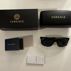Versace solglasögon - Säljer ett par äkta Versace solglasögon.  Köpte dom för 1600kr och har använt dom ett fåtal gånger.  Kommer med allt original som kom vid köp så som fodral och kartong. Det har snygga guldiga bågar med logga som drar till sig ögonen.  Skriv vid frågor! Skickas samma dag vid köp