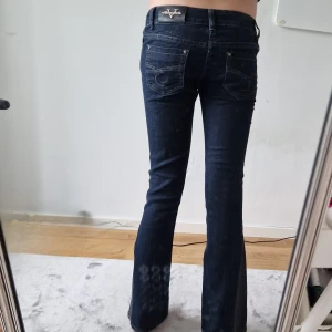 Lågmidjade jeans - Säljer ett par supernygga mörkblå jeans från vaiuabie. Storlek w24. Köpt i London för typ 750 men jag säljer för 399. Mycket bra skick. Kil längst ner på benet💕