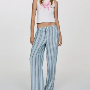 Randiga vida cargobyxor i linne - Snygga byxor med blå och vita ränder, vida ben och avslappnad passform. Byxorna har snörning i midjan och är tillverkade i svalt linne, perfekta för varma dagar. Fickor på sidorna. Helt nya aldrig använda med prislappen kvar🫶