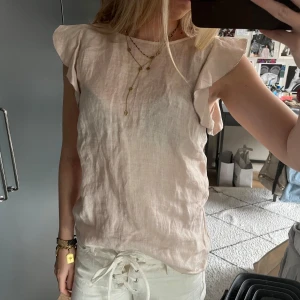 Ljusrosa linnetopp från Massimo Dutti - Supersöt ljusrosa linnetopp från Massimo Dutti med silver och volangdetaljer vid axlarna. 