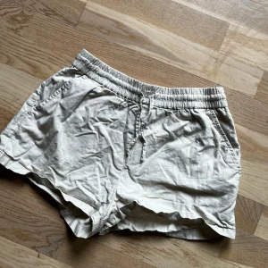 Beigea linne shorts - Säljer dessa linne shorts då de ej kommer till användning. Nu är de lite skrynkliga eftersom jag inte använd de på ett tag men efter en tvätt borde de bli normala igen. 