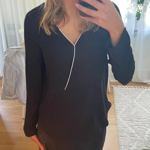 Svart blus Mango - Snygg svart blus från Mango med lång ärm och v-ringning. Vit kant längs ringningen. Storlek S💕