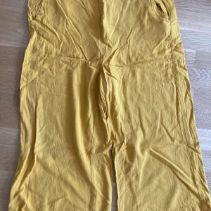 Gula linnebyxor från Hampton Republic - Snygga gula linnebyxor från Hampton Republic i storlek M. Byxorna har elastisk midja och raka, lite vidare ben. Perfekta för varma dagar och ger en chill vibe till din outfit.