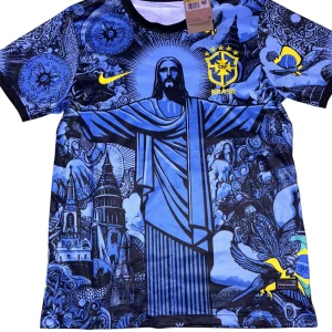 Nike Brasil blå grafisk fotbollströja - Unik Brasilien fotbollströja från Nike med blått och svart grafiskt tryck av Kristusstatyn och brasilianska symboler. Gult CBF-märke och Nike-logga på bröstet. Tillverkad i lätt Dri-FIT polyester som andas. Svart baksida och korta ärmar.
