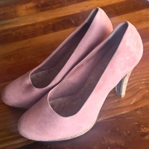 Pumps - Pumps i rosa mocka (imitation), klacken och sula i kork. Storlek 39. Använda 1 gång därmed i nyskick. 