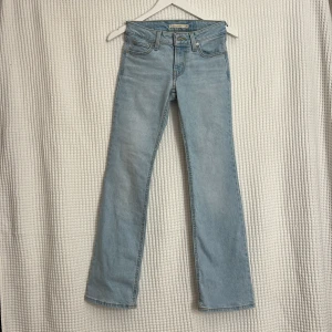Levi's Superlow Bootcut ljusblå jeans - Snygga ljusblå Levi's Superlow Bootcut jeans med klassisk femficksdesign och låg midja. Jeansen har bootcut-ben och är tillverkade i mjukt denim med tydliga Levi's-detaljer som läderpatch och röda etiketten bak. God skick