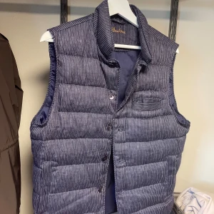 Randig dun/linne väst från Stenströms - Snygg dunväst från Stenströms i mörkblått med tunna vita ränder. Västen har en klassisk krage, knäppning framtill och en liten bröstficka. Perfekt för lager-på-lager och ger en stilren look.