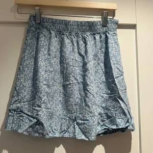 Blommig blå kort kjol - En så somrig o fin blå/grön kort kjol med små blommor på. 