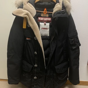 Svart Parajumpers dunjacka XS med päls - Säljer en svart Parajumpers dunjacka modell Musher i storlek XS. Jackan har fluffig päls på huvan, stora fickor, coola badges och detaljer som dragkedja och knappar. Perfekt för kalla dagar och riktigt snygg streetstil. Använd fåtal gånger, pris diskuteras vid snabb affär.