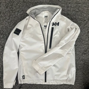 Helly Hansen Jacka - Helly Hansen Jacka i använt skick. Tunn jacka. Storlek XS. Passar S, men sitter litet. Skriv om bild med med den på eller andra frågor. Inga defekter förutom lite smutsig på vissa ställen men försvinner i tvätten.