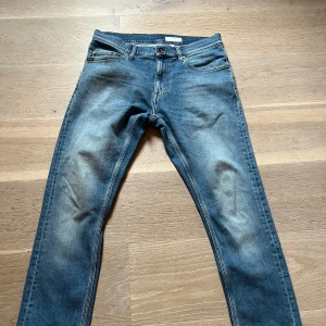 Blå slim fit jeans från tiger of Sweden. - Säljer ett par klassiska blå jeans med snygg tvätt och lätt slitning. Modellen är slim fit med normal midja och raka ben. Jeansen har fem fickor och stängs med dragkedja och knapp. Perfekta till sneakers och hoodie. Storlek 30,30