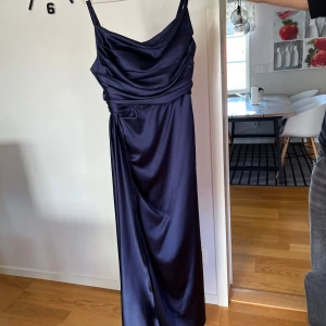 Mörkblå långklänning i satin - Hejsan! Jag säljer min mammas klännning hon har använt 1 gång. Den är storlek 44 men är mer som 42.  Skriv gärna om ni har frågor och jag bor i Eslöv om man vill mötas!