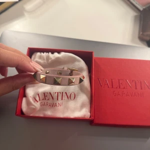 Valentino armband - Supersnyggt rosa armband från Valentino i läder med guldfärgade nitar och spänne i guld. Kommer i original ask och dustbag. Köpt förra året, sparsamt andvänt. Man får även med två extra nitar! Äkthetsbevis kan skickas vid intresse av köp! Köpt för 2995kr, kostar nu 3085kr!