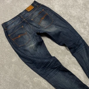 Nudie Grim Tim - Tja! Säljer dessa sjukt snygga mörkblå/grå fade Nudie Grim Tim jeansen med störd tvätt! Jeansen är i size 32/34 och har en slimfit passform. Skriv vid funderingar!