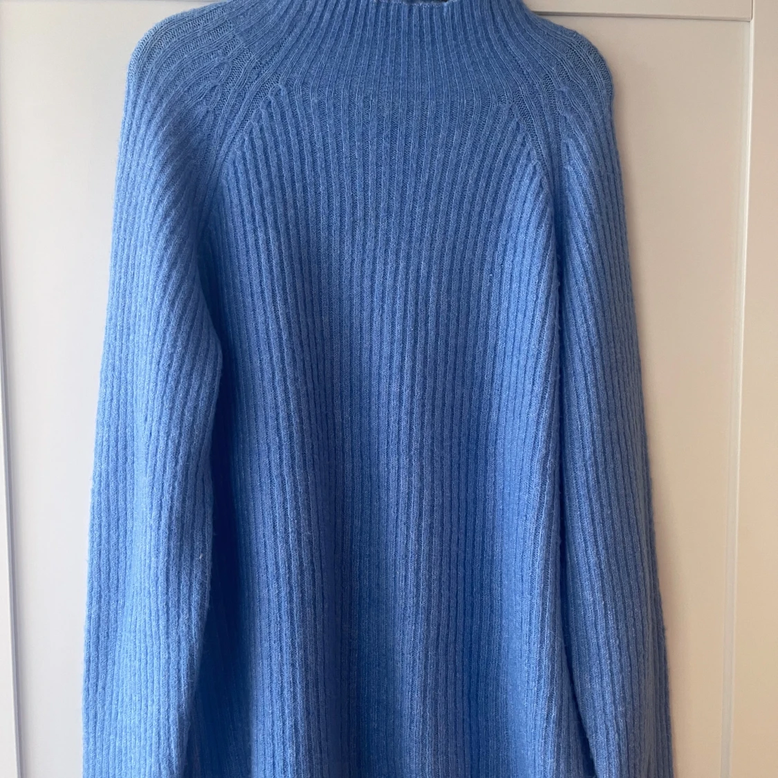 Blå ribbstickad tröja med hög krage