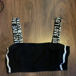 Topp - Säljer en svart topp med vita detaljer. tyvärr vet jag inte storlek eller märke då alla lappar är bortklippta, men jag skulle uppskatta den till storlek S. Den har inte ställbara axelband, men axelbanden är stretchiga. 