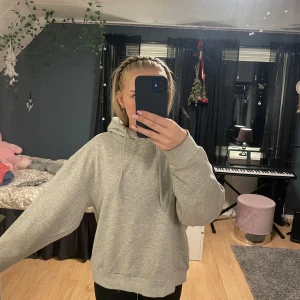 Grå hoodie med luva - Säljer en enkel och stilren grå hoodie med luva och snören. Använd några gånger men fortfarande bra skick. 