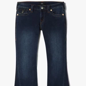 Mörkblå bootcut jeans från True Religion - Snygga mörkblå jeans från True Religion med låg midja och flare-stil. De har en klassisk femficksdesign med märkets ikoniska broderi på bakfickorna och en knappdetalj. Perfekta för en avslappnad och trendig look. Mått: innerbenslängd 79cm, midja tvärs över 39cm | när jag köpte dom så var dom för långa så har fått dom uppsydda så kolla räkna med nya mått och kvitto finns kvar ifall bild önskas.   STORLEK 27