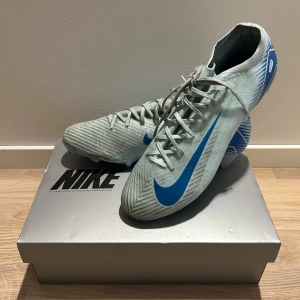 Nike Mercurial Air fotbollsskor - Säljer ett par Nike Mercurial Air fotbollsskor i ljusblå färg. Skorna är använda endast 2 gånger och i väldigt bra skick men tyvärr blivit lite missfärgade av konstgräset. Stlk 46 men passar även 45
