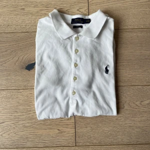 Polo Ralph lauren pique  - En stilren vit Polo Ralph lauren pique som är perfekt till en sommar outfit. Storlek är 170 och skick är väldigt bra. Använd fåtal gånger. Skriv om ni vill ha någon mer info eller om ni har några funderingar!