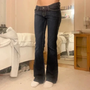 Mörkblå bootcut jeans från Guess - Säljer ett par mörkblå bootcut jeans med låg midja. Byxorna är från guess och har inga tydliga tecken på användning eller defekter! Midjemåttet är 38cm och innerbenslängden är 83cm