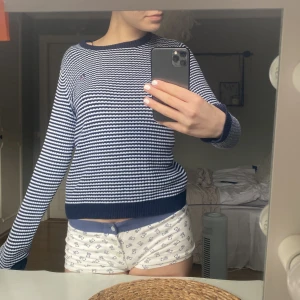 Randig stickad tröja från Bondelid - Säljer en blåvit randig stickad tröja från Bondelid i storlek XS. Tröjan har rund halsringning, långa ärmar och ett litet broderat Bondelid-märke på bröstet. Perfekt för en klassisk och avslappnad stil.