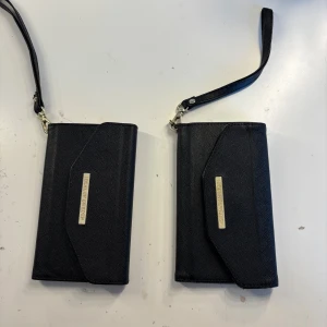 Svart mobilskal som ser ut som plånbok  - Svart mobilskal från ideal of sweden som liknar en plånbok. För iPhone 8💗Båda för 40kr eller 20kr styck💗 Använd inte köp nu!