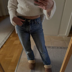 Blå raka jeans med hög midja - Säljer ett par klassiska blå jeans med raka ben och mid midja. Jeansen har fem fickor, gylf med dragkedja och knapp samt en tidlös tvätt. Perfekta för en avslappnad och stilren look. OBS uppsydda för mig som är 152cm