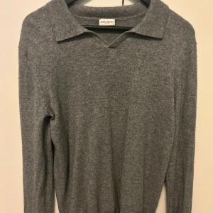 Grå kashmirtröja med krage från John Henric - Säljer en stilren grå långärmad tröja i 100% kashmir från John Henric. Tröjan har klassisk krage och mjuk känsla, perfekt för dig som gillar en enkel men lyxig look.