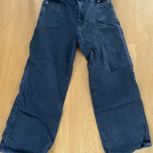 Mörkblåa wide jeans - Säljer ett par mörkblåa jeans med bred passform och raka ben. Klassisk femficksmodell och knappgylf. Perfekta för en avslappnad och trendig stil.
