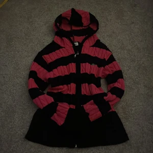 Svart och rosa randig hoodie med dragkedja - Säljer en svart och rosa hoodie med breda ränder och dragkedja framtill. Jackan har huva och även två fickor. Ger lite 2000s vibe om du tycker om de🤗 