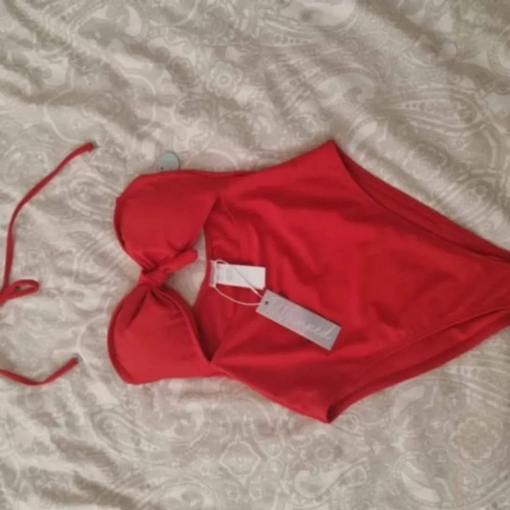 Snygg röd baddräkt från ReVamped med knyt-detalj framtill och avtagbara axelband. Baddräkten har en feminin passform och är tillverkad i ett mjukt material som känns bekvämt mot huden. Perfekt för strand eller pool!. Muu.