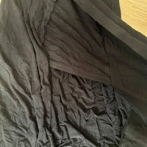 Svart klänning från BCBGeneration - Säljer en svart klänning från BCBGeneration. Klänningen har en enkel och stilren design med mjukt tyg och lätt rynkade detaljer. Perfekt för dig som gillar klassiska plagg med en modern touch.