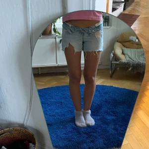 Ljusblå jeansshorts  - Säljer ett par ljusblå jeansshorts med snygga slitna detaljer.  Blir as snyggt om man viker ner kanten som jag gjort på bilden! De är jättesnygga och perfekta till sommaren men har tyvärr blivit försmå för mig.
