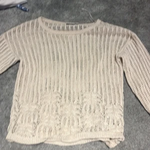 Beige stickad tröja från VILA - Säljer en beige stickad tröja från VILA med lång ärm och ett snyggt genombrutet mönster. Tröjan har rund halsringning och är perfekt för lager-på-lager-stil. Passar dig som gillar en luftig och avslappnad look. Funkar även som strand cover up