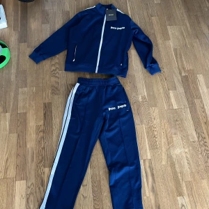 Blå tracksuit från Palm Angels - Hej! Säljer nu min mörkblåa Palm angels tracksuit, aldrig använd och har förvarats i gott skick, säljes nu för att den aldrig används längre, storlek är S och byxorna passar dig som är 172-181, och tröjan skulle jag säga 176-183 på ett ungefär. Om ni har frågor eller vill ha flera bilder är att bara att skriva privat😀