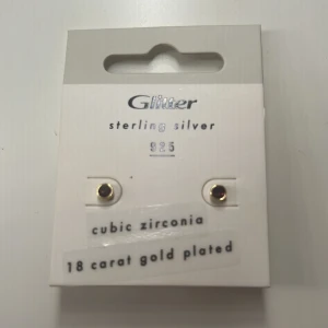 Guldpläterade örhängen med cubic zirconia från Glitter - Säljer ett par små örhängen från Glitter i sterling silver 925, pläterade med 18 karat guld och med cubic zirconia-stenar. Perfekta för en stilren look.