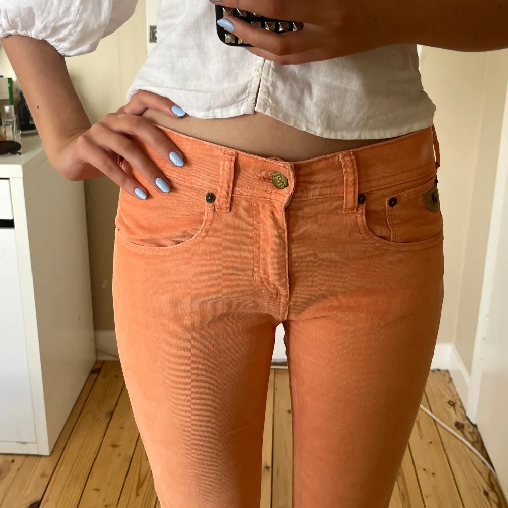 Säljer dessa suuupersnygga jeans i Manchester tyg, i en orange/aprikos/korall färg. Jag är 172 för referens🧡 Storleken är 27/32. Lite smutsiga längst ner vid hälen på ena byxbenet, visas på bild. midjemåttet är 35 cm tvärs över och innerbenslängden är 74 cm🧡. Farkut & Housut.