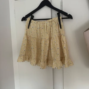 Kjol från Nelly - Supersöt gul kjol från NLY Trend med blommigt mönster och volangkant. Kjolen har resår i midjan och är perfekt för sommaren! Fin skick och inte används så mycket! Skriv vid fundering eller intresse!❤️🙏
