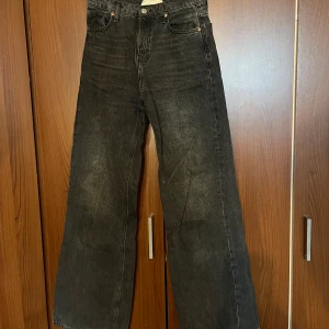 Svarta wide jeans från Topshop - Säljer ett par högmidjade vida svarta/gråa jeans från Topshop. Enkel design som kan användas i alla sammanhang🥰 för små för mig men riktigt snygga. W 26, L 34