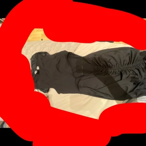 Svart klänning med rynkade detaljer - Säljer en svart klänning i storlek S med snygga rynkade detaljer framtill. Klänningen har korta ärmar och markerad midja, vilket ger en smickrande siluett. Perfekt för dig som gillar en klassisk och stilren look.