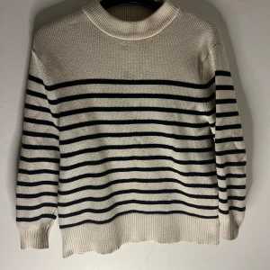 Tröja ifrån Zara - Säljer en vit stickad tröja från Zara med marinblå  ränder. Tröjan har rund halsringning och långa ärmar. Perfekt för en kallare dag nu till sommaren❤️går heller inte att köpa längre.