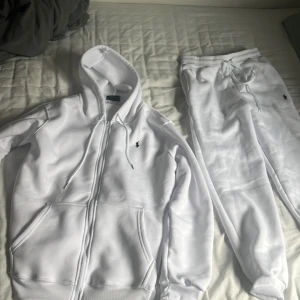Vit mjukis set från polo  - Säljer ett par vita mjukisbyxor från Polo Ralph Lauren med dragsko i midjan och liten broderad logga på höften. Byxorna är i mjukt material och har en avslappnad passform, perfekta för chill dagar.