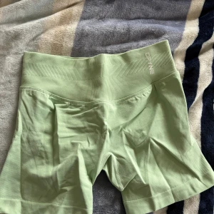 Ljusgröna träningsshorts från DFYNE impact 4.5 - Snygga ljusgröna träningsshorts från DFYNE med bred ribbad midja för extra komfort. Shortsen är sömlösa och har en tight passform som passar perfekt till träning eller vardagsaktiviteter.